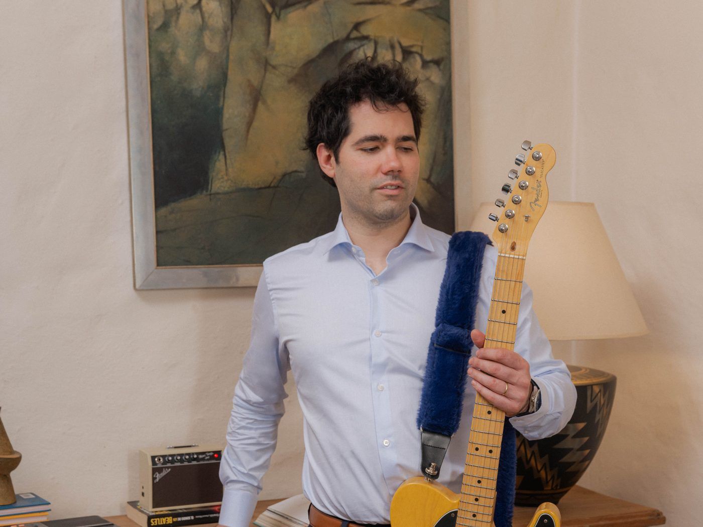 Alejandro Piñeyrúa toca una guitarra eléctrica en el taller.